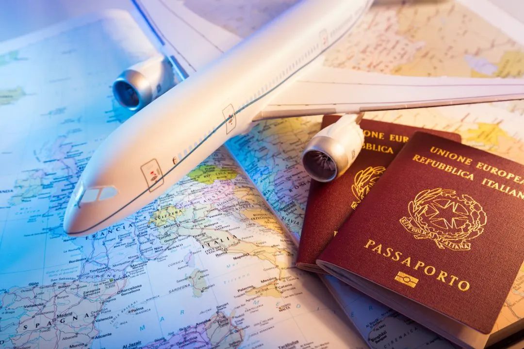 Foto di una cartina, un aereo in miniatura e due passaporti che simboleggiano il viaggiare